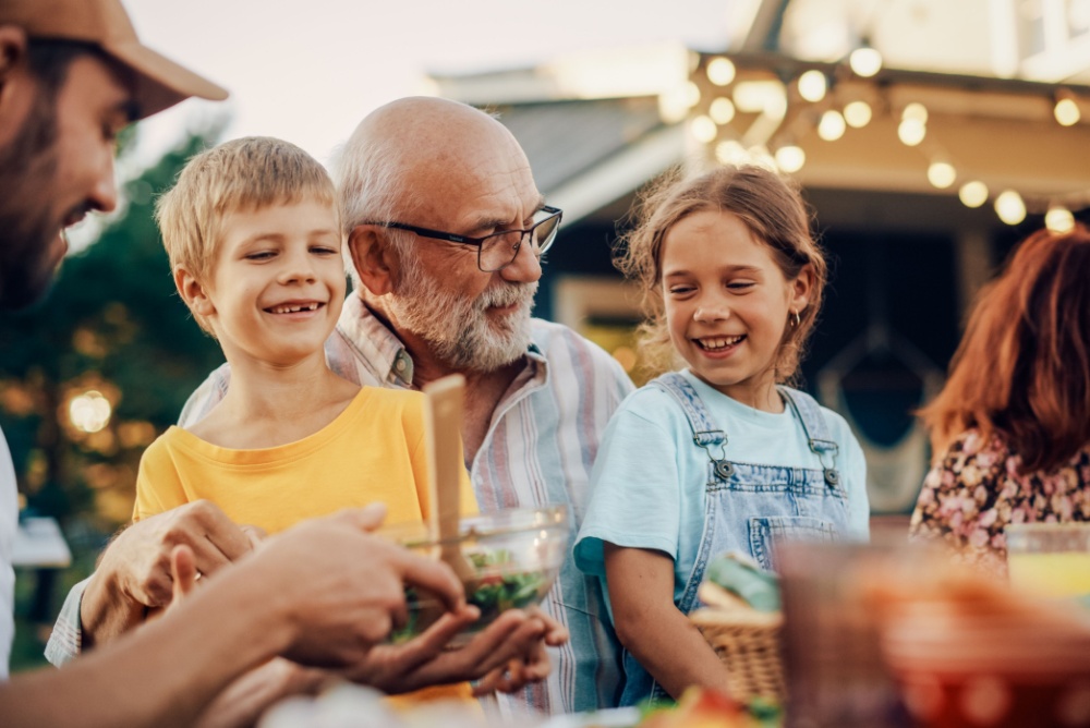 A grandfather laughing with his grandchildren.