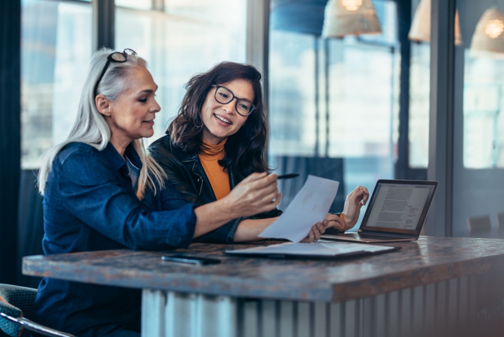 A woman talking to a colleague in an office.