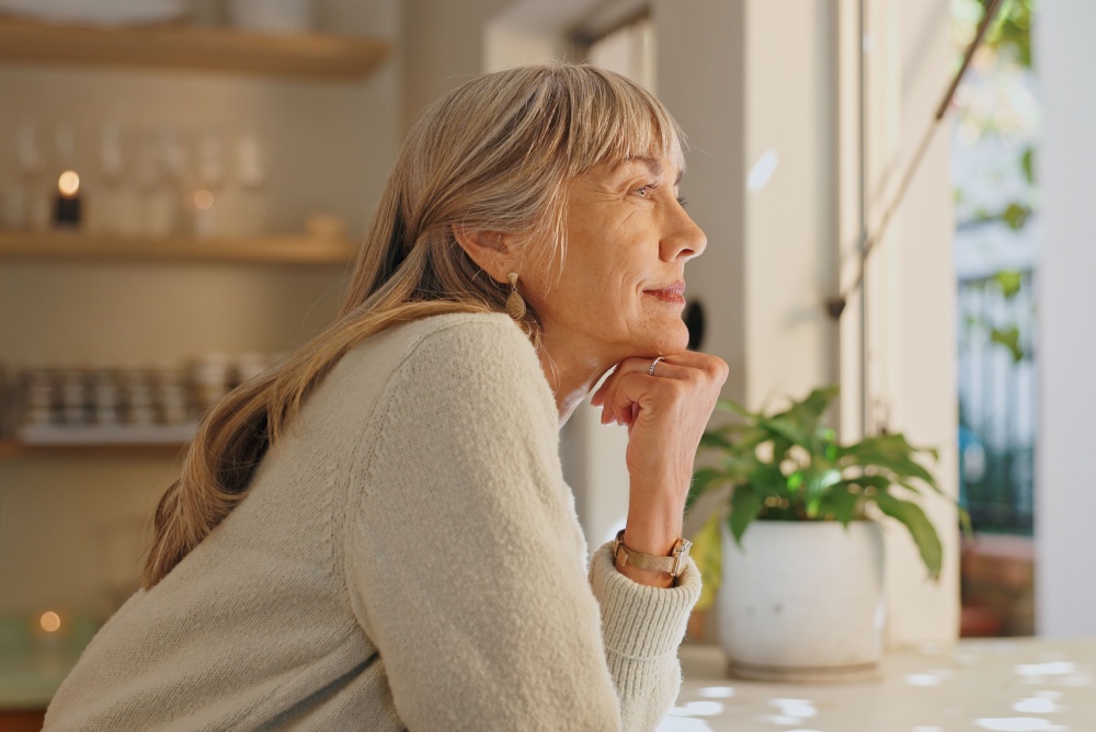 A woman looking out of the window at home.