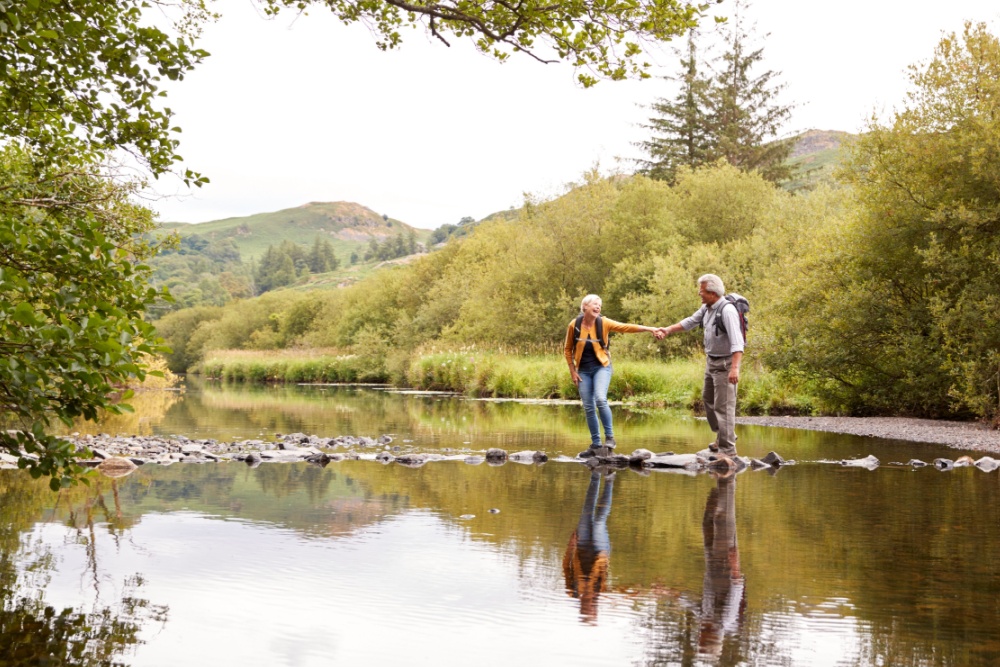 A couple walking across stepping stones.